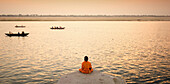 Man meditating in fron of the Ganges, Varanasi. Uttar Pradesh, India