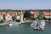 Excursion boats in harbour with Mang tower, Lindau, Bavaria, Germany