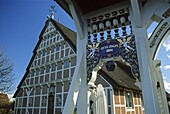 Kunstvoll verziertes Hoftor vor reetgedecktem Fachwerkhaus, Altes Land, Niedersachsen, Deutschland