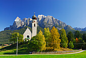 church St. Konstantin with trees in autumn colours beneath Schlern, Dolomites, South Tyrol, Italy