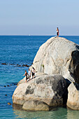 Menschen stehen auf einem Fels am Boulders Strand, Simon's Town, Cape Peninsula, Südafrika, Afrika