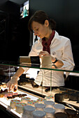 Sales girl with pralines in the Patisserie Zum Schwarzen Kameel, Vienna, Austria