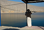 Local fisherman standing on the waterfront, Al Hajar mountains, Musandam, Oman, Asia