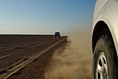 All-terrain vehicles driving on a sandy road under blue sky, Wahiba Sands, Oman, Asia