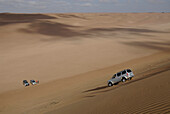 Ein Geländewgen fährt eine Sanddüne hinunter, Wahiba Sands, Oman, Asien