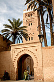People walking through a gate of the Kutubiya mosque, Marrakesh, Morocco, Africa