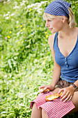 Junge Frau isst eine Brezel, Werdenfelser Land, Bayern, Deutschland