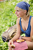 Junge Frau isst eine Brezel, Werdenfelser Land, Bayern, Deutschland