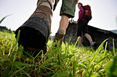 Hikers near wooden lodge, Wetterstein range, Bavaria, Germany