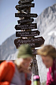 Two young women near sign post, Werdenfelser Land, Bavaria, Germany