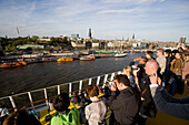 Menschen auf einem Kreuzfahrtschiff fotografieren den Hafen, Hamburg, Deutschland