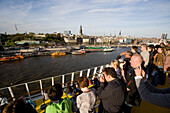 People on a cruise ship taking pictures of the harbour, Hamburg, Germany