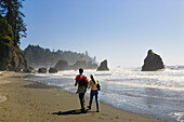 Hikers at the beach in the sunlight, Olympic Peninsula, Washington, USA