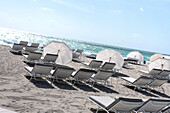 Sonnenliegen und Sonnenschirme am Strand im Sonnenlicht, South Beach, Miami Beach, Florida, USA