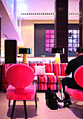 Ein Mann sitzt in der Lobby des Gaansevoort South Hotel, South Beach, Miami Beach, Florida, USA