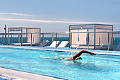 A person swimming in the rooftop pool of the Gaansevoort South Hotel, South Beach, Miami Beach, Florida, USA