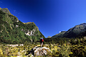 Einsamer Trekker am Kepler Track im Iris Burn Valley unter blauem Himmel, Fjordland Nationalpark, Südinsel, Neuseeland, Ozeanien