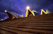 Blick auf Stufen vor dem beleuchteten Opernhaus am Abend, Sydney, New South Wales, Australien