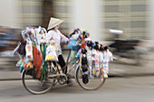 Woman street vendor pushing a bicycle, Hanoi, Vietnam