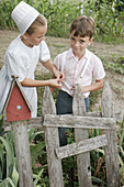 Amish Farm Tour, boy, girl, suspenders, garden. Shipshewana. Indiana. USA.