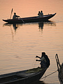 Boats with pilgrims and tourists at dawn in Varanasi, India, a sacred Hindu pilgrimage site.