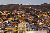Overview of city at dusk, view from El Pipila monument, university building and churches spread in valley  Guanajuato, Mexico