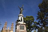 Miguel Hidalgo monument in plaza, honor Father of Mexican Independence, city where cry of freedom made, twin church towers  Dolores Hidalgo, Mexico