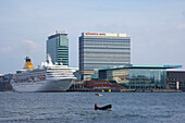 Kreuzfahrtschiff auf dem Fluss Het Ij neben Hochhäusern, Amsterdam, Niederlande, Europa