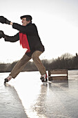 Person helping ice skater to stand up, Lake Ammersee, Upper Bavaria, Germany