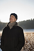 Senior man with closed eyes standing in winter scenery, Windach, Upper Bavaria, Germany