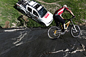 Mountainbiker riding on a steep rock face, Ischgl, Tyrol, Austria