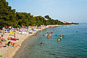 Menschen entspannen sich am Strand von Tucepi, Makarska Riviera, Dalmatien, Kroatien, Europa