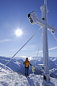Woman at summit cross, Wiedersberger Horn, Kitzbuehel Alps, Tyrol, Austria
