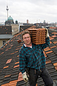 Blick über Berliner Dächer, Dachdecker schleppt Dachziegel auf Berliner Dach, Unter den Linden
