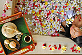 Eine Frau badet in einer Badewanne mit Blüten, Spa des Chedi Club, GHM Hotel, Ubud, Indonesien, Asien