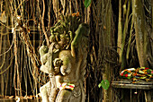 Balinese stone figure in front of a tree, Jimbaran, Bali, Indonesia, Asia