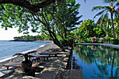 Deserted pool under palm trees at the beach, Mimpi Resort at Tulamben, North East Bali, Indonesia, Asia