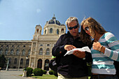 Couple checking the map outside the Kunsthistorische Museum  (Art History Museum), Vienna, Austria.