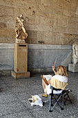 Designer in front of a statue in the Ancient Agora Museum (Stoa of Attalos), Athens. Greece