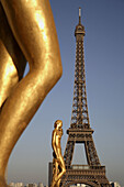Gilded bronze statue decorating the central square of the Palais de Chaillot with Eiffel Tower in the background. Paris. France