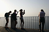 Visitors look at the Sorrento Bay from a lookout from top of the coast cliff. Sorrento. Campania. Italy