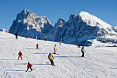 Skifahrer auf einer Skipiste unter blauem Himmel, Seiser Alm, Eisacktal, Südtirol, Italien, Europa