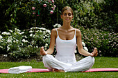 Frau im Schneidersitz, macht Yoga Übungen, Meditation, Entspannung, Wellness, Urlaub, Südtirol, Italien