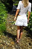 Young woman walking through a stream, Kneipp therapy, Hydrotherapy, relaxation, South Tyrol, Italy