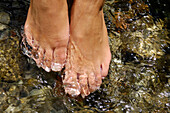 Young woman walking barefoot through a stream, Kneipp therapy, Hydrotherapy, relaxation, South Tyrol, Italy