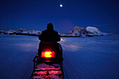 Mann auf Motorschlitten im Mondlicht, Schneemobil, Skidoo, Langkofelgruppe, Südtirol, Italien