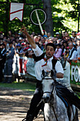A man on his horse galopping at a horse show in front of spectators, South Tyrol, Italy, Europe