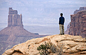 Hiker enjoys the view of Candlestick Tower in Canyonlands National Park, Moab, Utah, USA