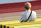 An old man at stadium bench