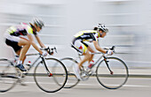 Cyclists compete in a road race in Warwick, England, UK